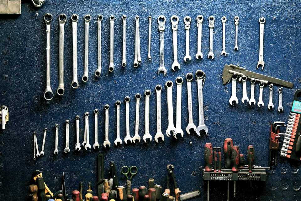 Ordentlich angeordnete Schraubenschlüssel und Werkzeuge an einer Werkstattwand, ideal für Mechaniker.