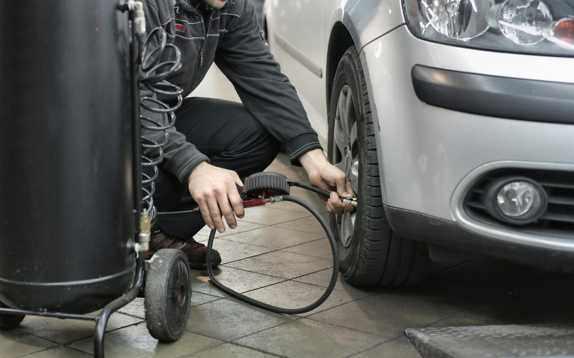 Mechaniker prüft und passt den Reifendruck in einer Autowerkstatt an.