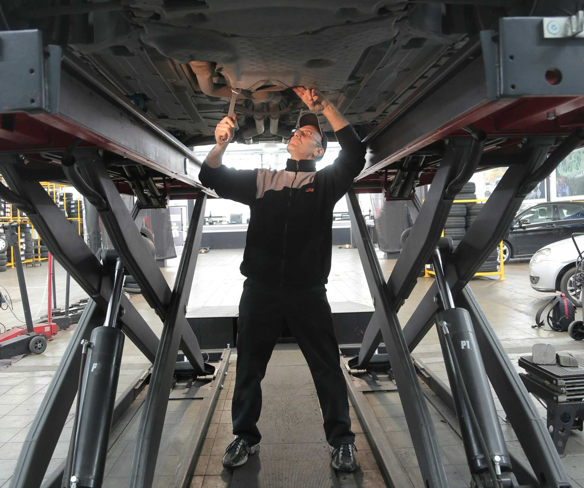 Mechaniker inspiziert und repariert ein Fahrzeug in einer professionellen Autowerkstatt.