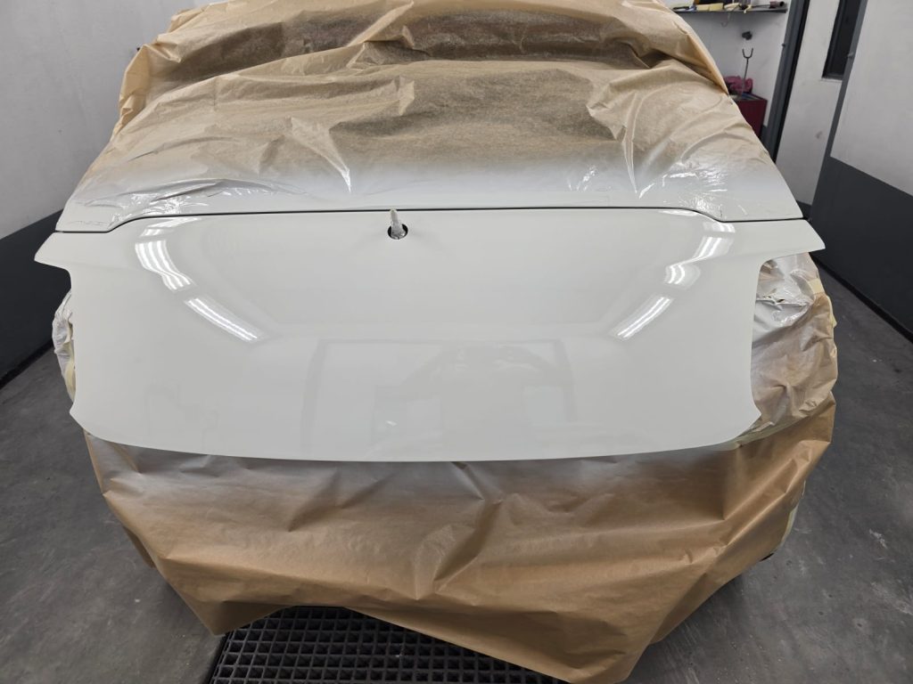 Glänzend fertig lackierte Heckklappe in Weiß, perfekt poliert und bereit zur Montage.
