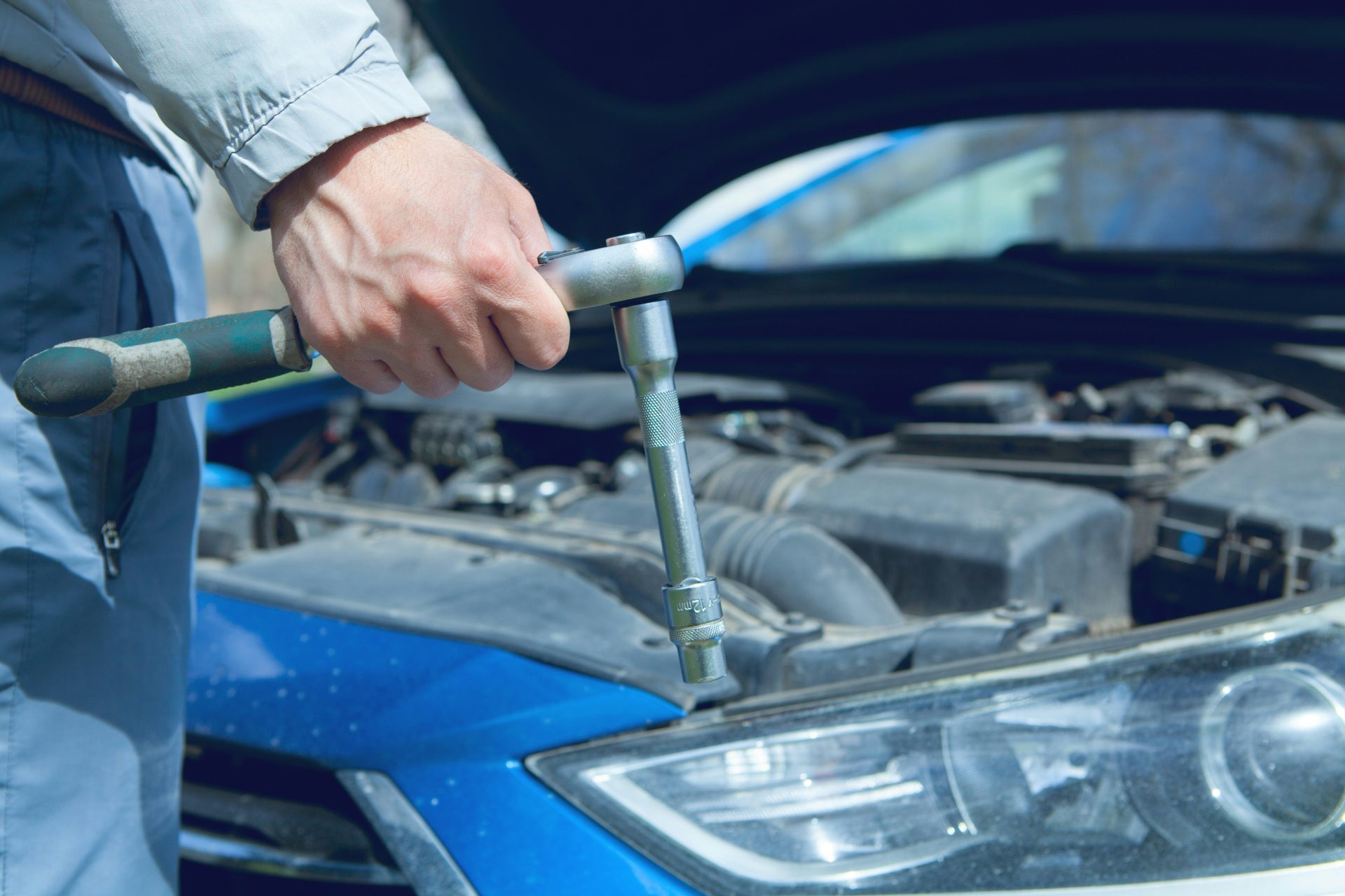Ein Mechaniker benutzt einen Schraubenschlüssel an einem Automotor.